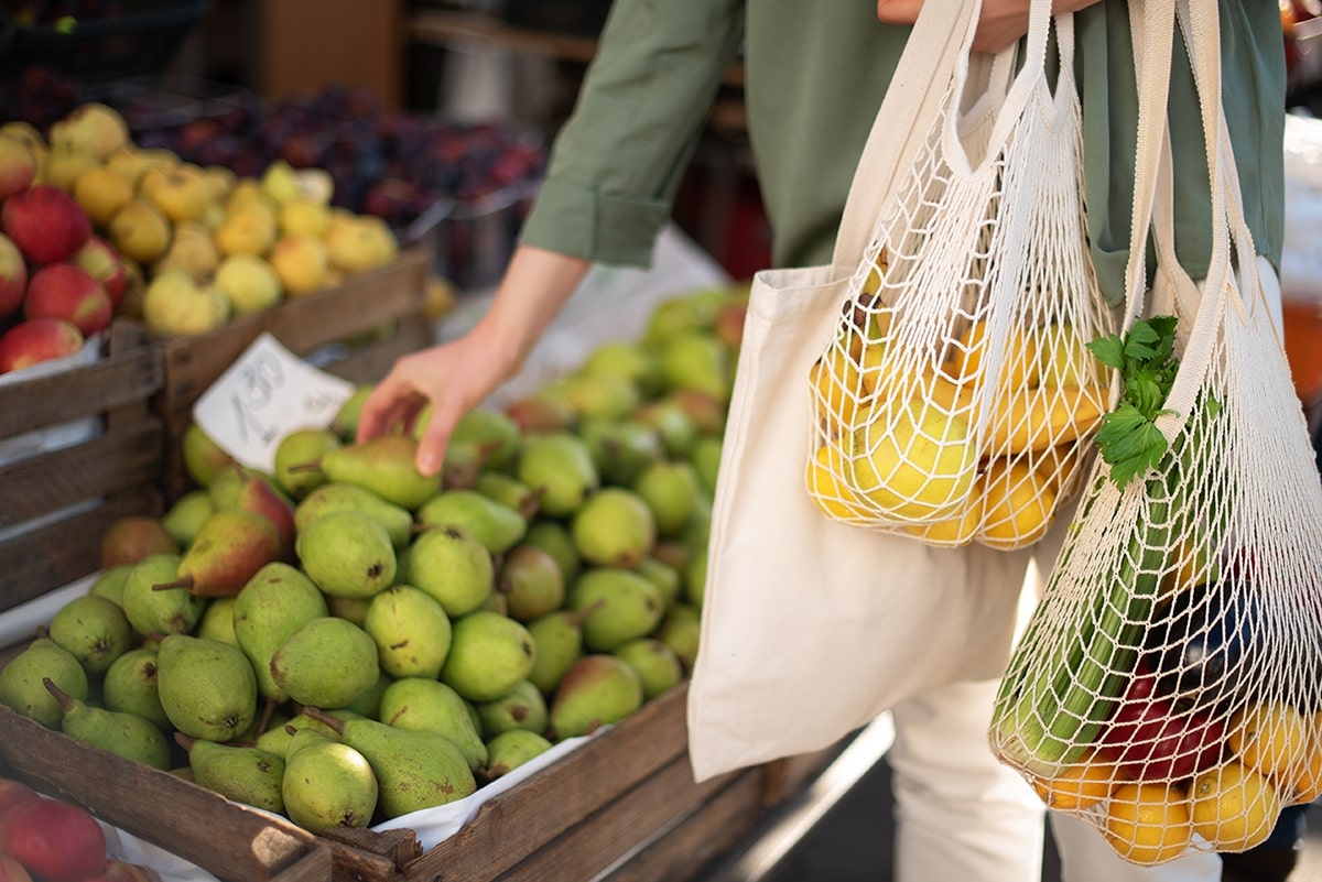 Shopper selects fruit and puts it into sustainable bags